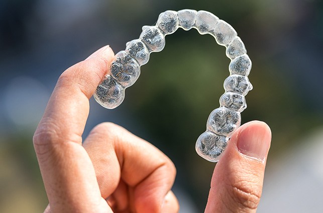 a patient holding their Invisalign tray