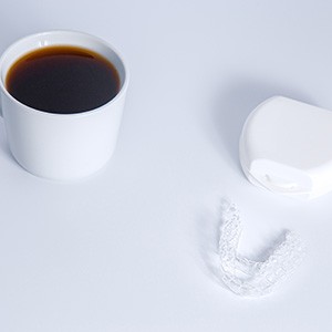 Invisalign next to a cup of coffee