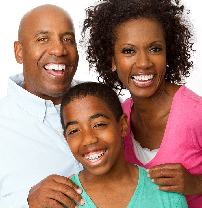 Teen boy with braces and his parents smiling together