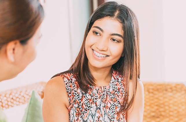 Woman with braces smiling at her friend