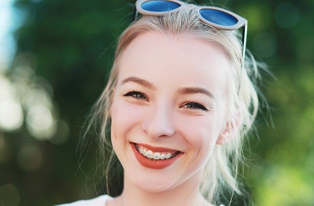 Woman with braces smiling outdoors