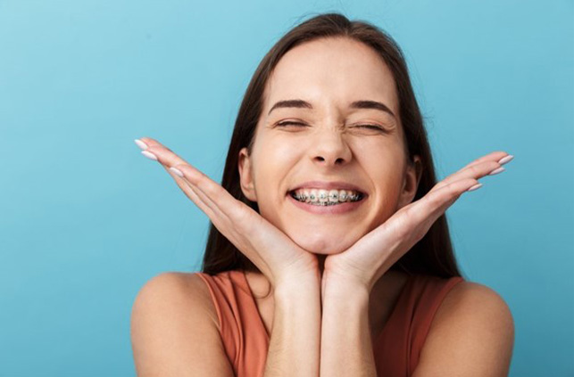 a patient pointing towards her traditional braces