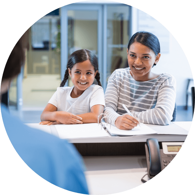 Mother and daughter checking in at orthodontic office reception desk