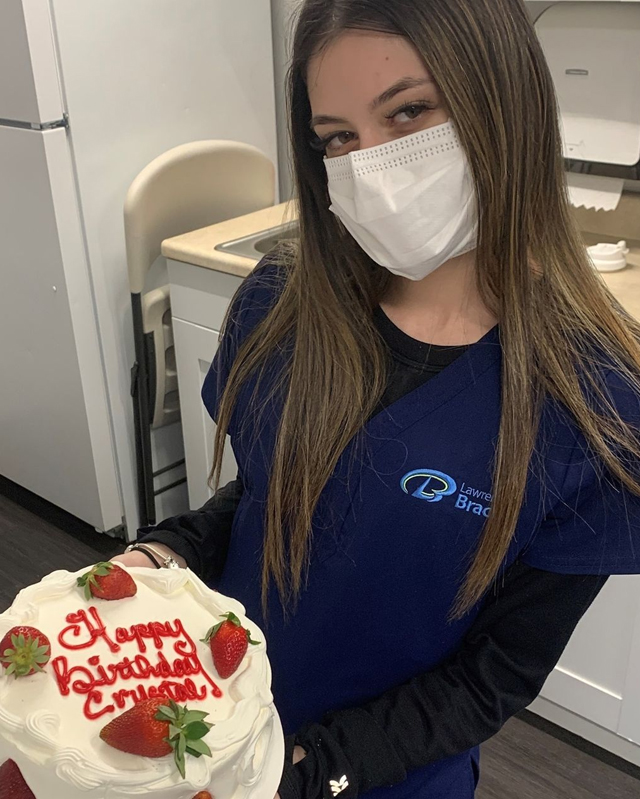 Orthodontic team member holding a birthday cake