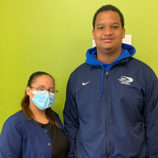 Dental team member and patient smiling