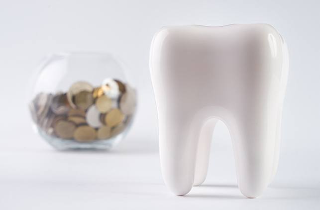 Model tooth and jar of coins