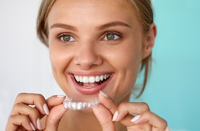Woman placing an Invisalign tray