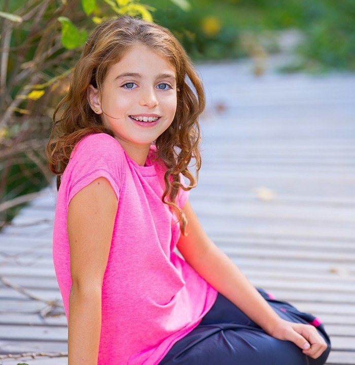 Young girl with orthodontic appliance smiling