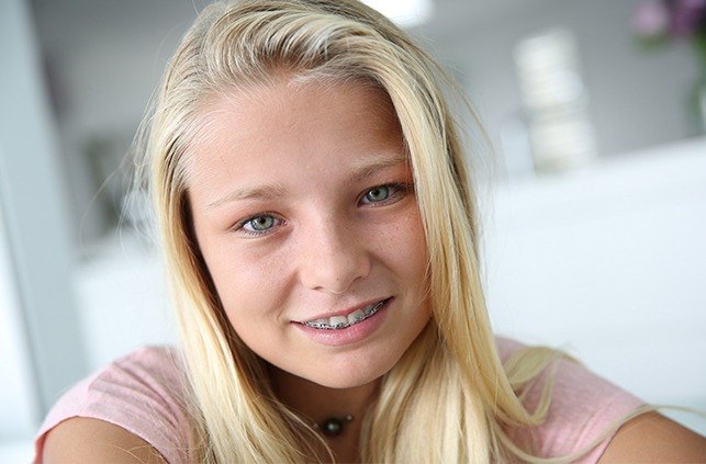 Preteen girl with pediatric orthodontics smiling