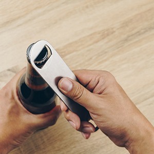 Closeup of patient using bottle cap opener