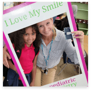 Child and orthodontic team member posing together