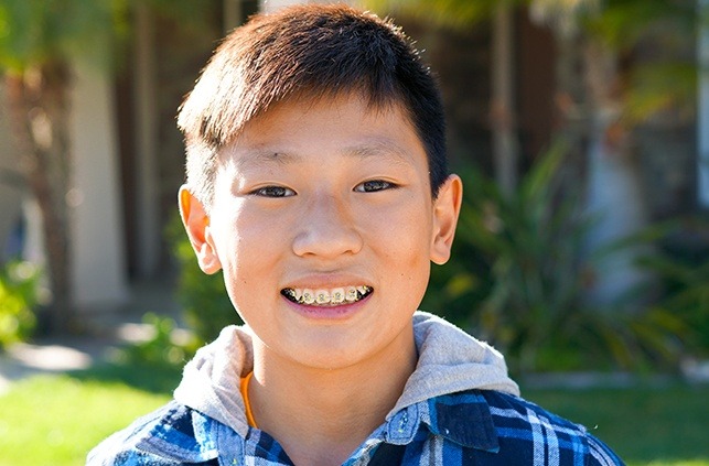 Teen boy with traditional braces smiling