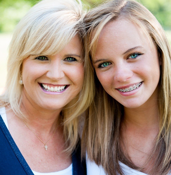 Teen girl with traditional braces and her mother smiling together