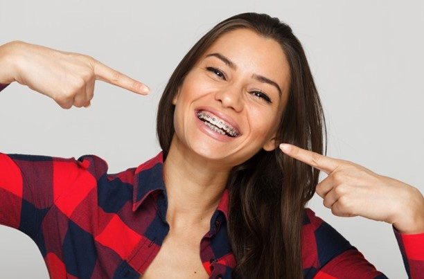 a patient pointing towards her traditional braces