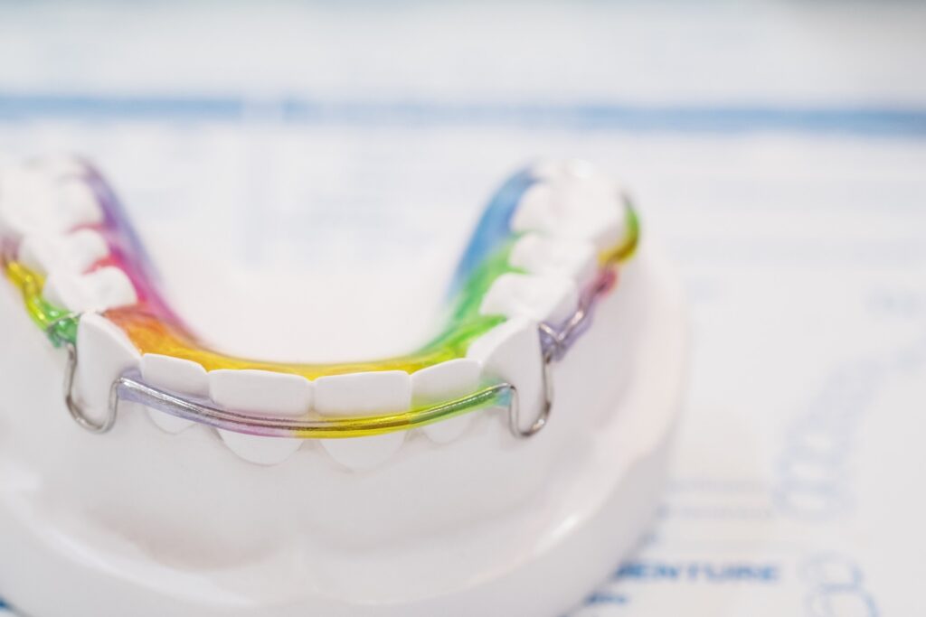 Closeup of colorful retainer on mold of teeth