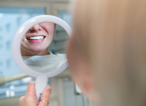 a person examining their teeth in a mirror