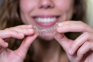 a patient holding their Invisalign aligner